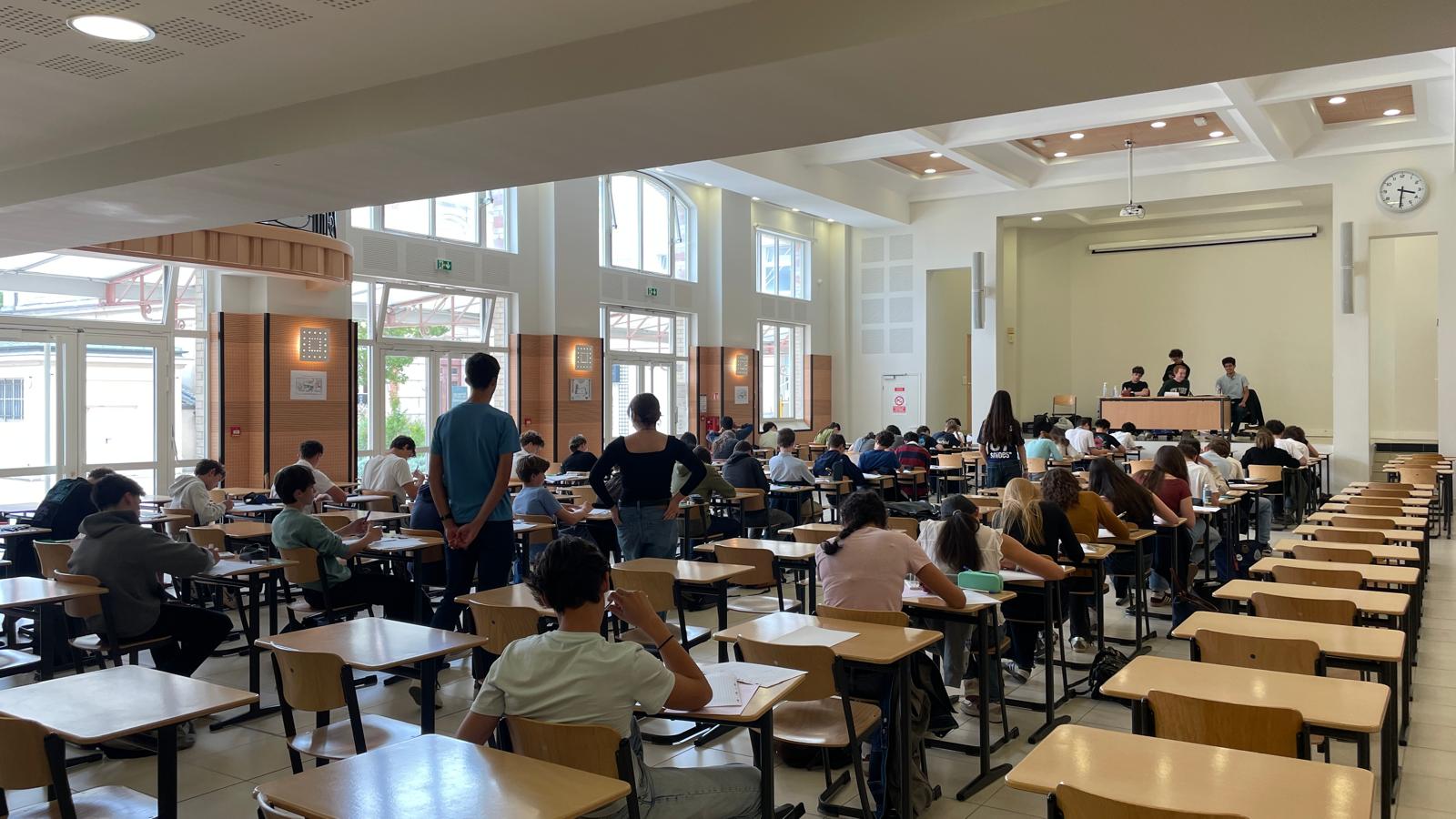 Salle d'examen du lycée pendant l'épreuve de recherche du concours du Programme Lang, juin 2026.